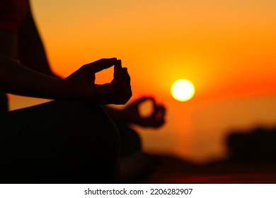 Backlight Silhouette Of A Yogi Hands At Sunset Doing Yoga On The Beach