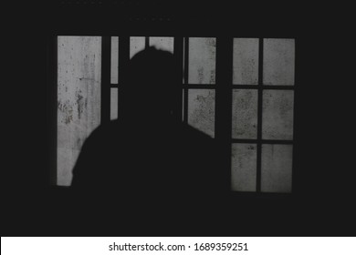 A backlighting of a guy in a window
