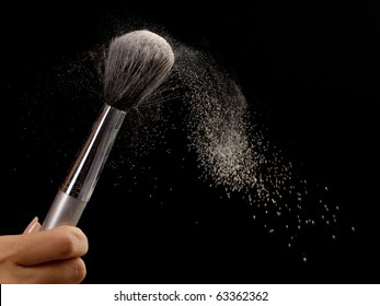 Backlit blowing to red brush with powder making a powder cloud on black background - Powered by Shutterstock