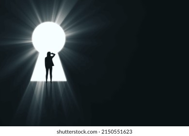 Backlit businesswoman standing in bright keyhole opening on dark background with mock up place and light rays. Dream, future and opportunity concept