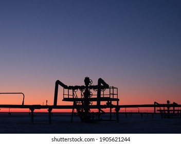 Backlit gas well against the blue sky. Oil and gas industry. Group bends and fittings, high pressure gas pipeline. Art noise