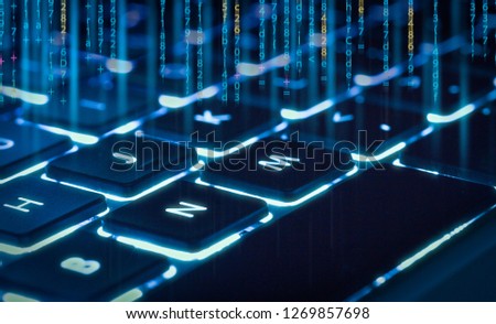backlit keyboard  with piece of code in background