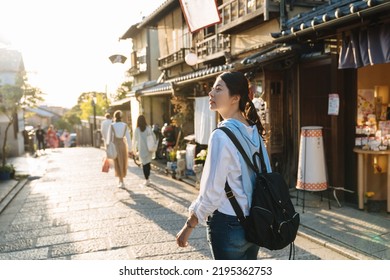backlit photograph asian female backpacker is gazing into the distance with curiosity while walking down historic ninen zaka street at dusk in autumn Kyoto japan - Shutterstock ID 2195362753