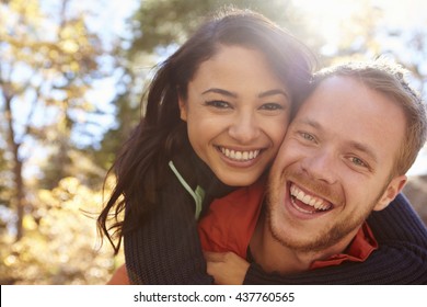 Backlit Portrait Of Mixed Race Couple Embracing In A Forest