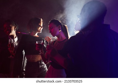 Backlit Portrait Of Young Woman Enjoying Drink On Dance Floor In Smoky Club, Copy Space