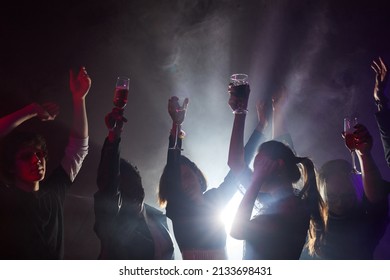 Backlit Shot Of Diverse Young People Dancing At Party, Silhouettes In Smoky Club