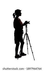 Backlit Silhouette Of A Female Photographer Hiking And Isolated On A White Background For Composites.  She Is Holding A Camera And Posing As A Journalist Or A Hobbyist