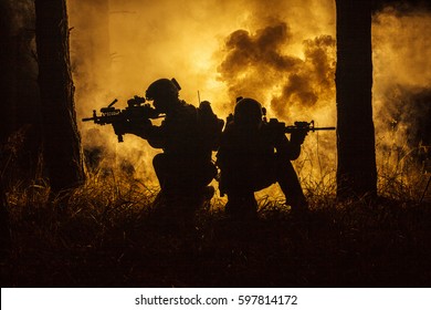 Backlit Silhouette Of Special Forces Marine Operators In Forest On Fire Explosion Background. Battle, Bombs Exploding, They Fighting No Matter What