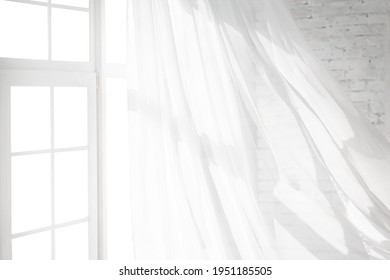 Backlit window with white curtains in empty room