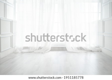 Backlit window with white curtains in empty room