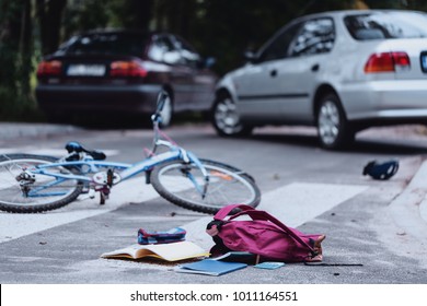 Backpack And Broken Child's Bike On The Street. Child Hit By A Car Concept