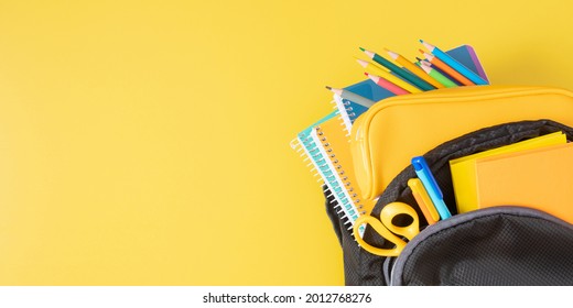 Backpack With Colorful School Supplies On Yellow Background. Back To School. Flat Lay, Top View, Copy Space