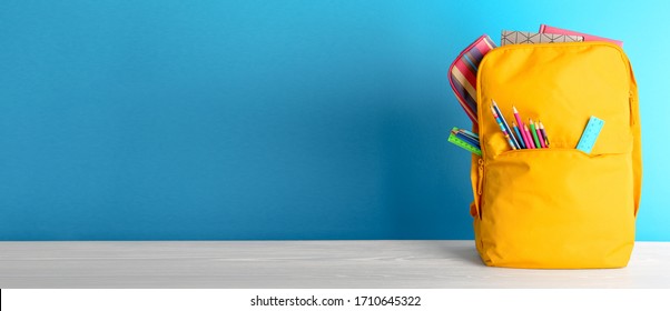 Backpack with different colorful stationery on table. Banner design - Shutterstock ID 1710645322
