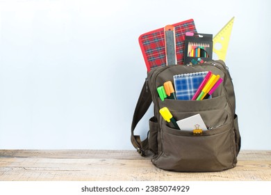Backpack with different colorful stationery on table. White background. Back to school - Shutterstock ID 2385074929