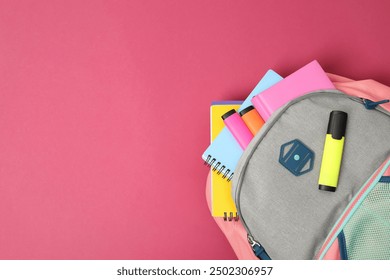 Backpack with different school supplies on pink background, top view. Space for text - Powered by Shutterstock