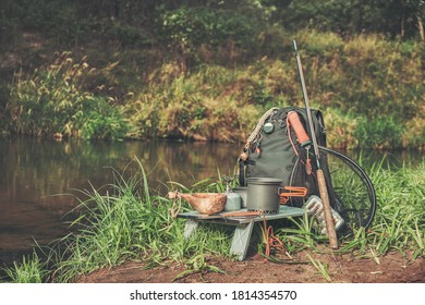 Backpack and fishing rod on the river. Fishing gear.