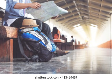Backpack and hat at the train station with a traveler. Travel concept. - Shutterstock ID 413464489