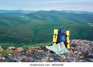 Backpack and map in mountain.