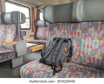 Backpack On An Empty Train Seat. Old Colorful Interior Of Train Cart With No Passengers