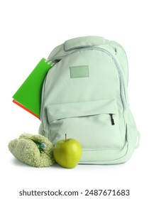 Backpack with pencil case, notebook and green apple on white background