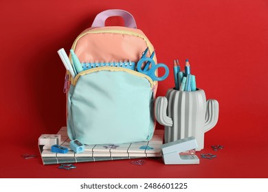 Backpack and pencil holder with stationery on red background - Powered by Shutterstock