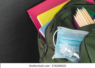 Backpack Prepared With Study Supplies And Mask For The Return To School. Covid-19 Concept.