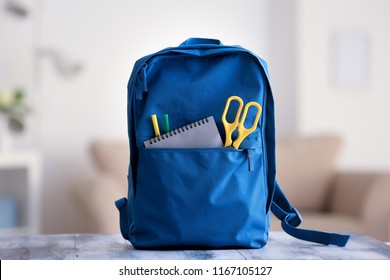 Backpack With School Supplies On Table