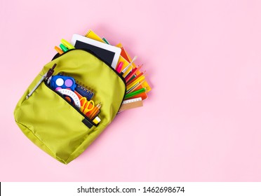 Backpack with school supplies spilling out pink ground. Back to School concept. - Powered by Shutterstock