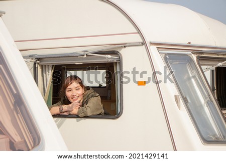 backpack solo female tourist having a happy summer vacation camping car in the morning
