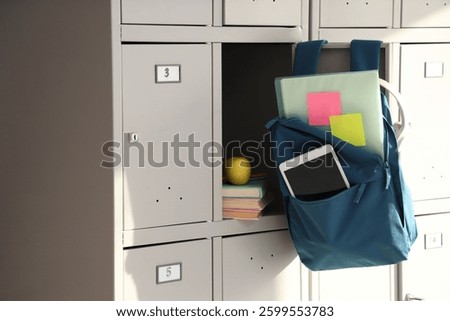 Backpack with tablet computer hanging on locker at school