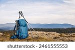 Backpack with tripod and hiking pole during trekking in mountains. Outdoor equipment for hike and trekking activity