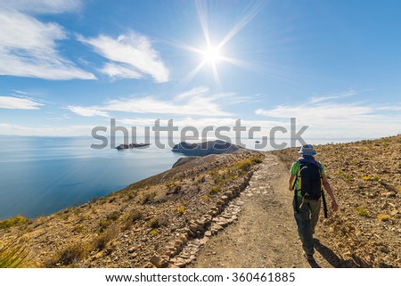 Backpacker exploring the Inca Trails on Island of the Sun, Titicaca Lake, among the most scenic travel destination in Bolivia. Travel adventures and vacations in the Americas. Shot in backlight.