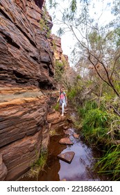 Backpacker Girl Hiking Through A Canyon In Karijini National Park In Western Australia, Hiking In The Australian Outback; Desert With Red Rocks