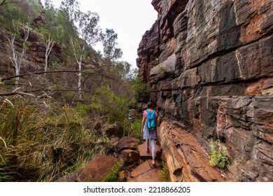 Backpacker Girl Hiking Through A Canyon In Karijini National Park In Western Australia, Hiking In The Australian Outback; Desert With Red Rocks