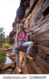 Backpacker Girl Hiking Through A Canyon In Karijini National Park In Western Australia, Hiking In The Australian Outback; Desert With Red Rocks