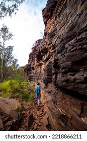 Backpacker Girl Hiking Through A Canyon In Karijini National Park In Western Australia, Hiking In The Australian Outback; Desert With Red Rocks