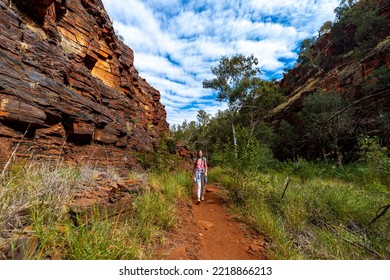 Backpacker Girl Hiking Through A Canyon In Karijini National Park In Western Australia, Hiking In The Australian Outback; Desert With Red Rocks