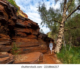 Backpacker Girl Hiking Through A Canyon In Karijini National Park In Western Australia, Hiking In The Australian Outback; Desert With Red Rocks