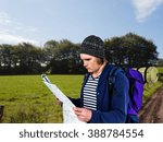 Backpacker looking a map against view of the countryside