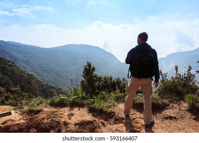 Backpacker looking at misty mountains
