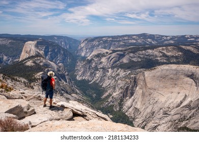Backpacker on top of Clouds Rest looking down into Yosemite Valley