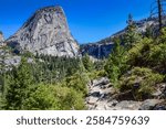 Backpacker on Vernal Falls Trail with scenic view of  Liberty Cap  from Clark Point in Yosemite National Park.