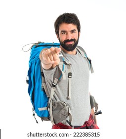 Backpacker pointing to the front over white background