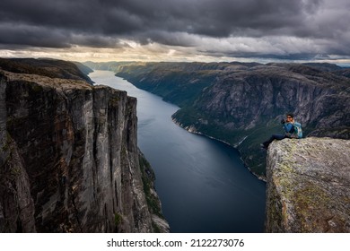 Backpacker Sits On Top Of The Eagle Head Viewpoint Near Kjeragbolten 