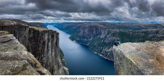 Backpacker Sits On Top Of The Eagle Head Viewpoint Near Kjeragbolten 