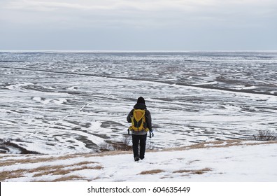 Backpacker walking on snow mountain in winter, at Iceland