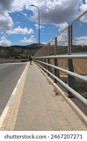 A backpacker walks on the side of the road