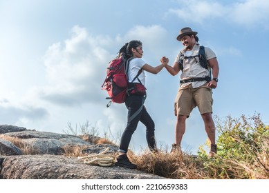 Backpackers, Asian Men And Women, Mountain Climbers. Hand In Hand On The Top Of The Mountain, Unity And Success Concept.