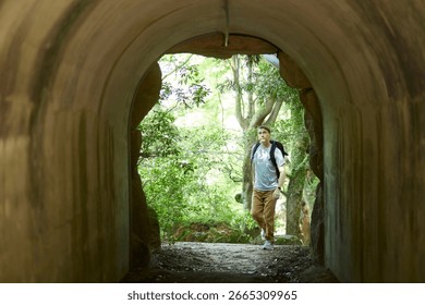 Backpackers exploring a forest tunnel