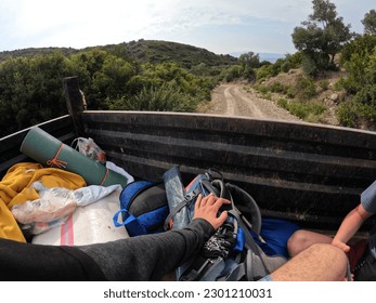 Backpackers also hitchhikers behind a tractor travelling inside a forest.(I have removed the brand names on bags now it's clear)